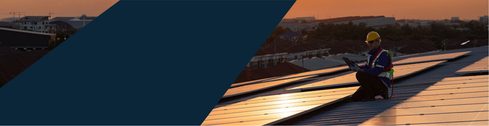 Techniker mit Helm und Sicherheitsweste prüft bei Sonnenuntergang eine Photovoltaikanlage auf einem Dach.