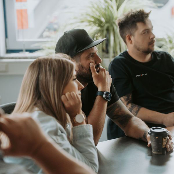 Ein engagiertes Team von Nexron-Experten und Kunden sitzt aufmerksam bei einer Schulung oder einem Planungsgespräch für Photovoltaik-Systeme zusammen.